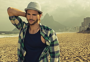 man wearing gray hat, blue and black plaid button up shirt and black tank top